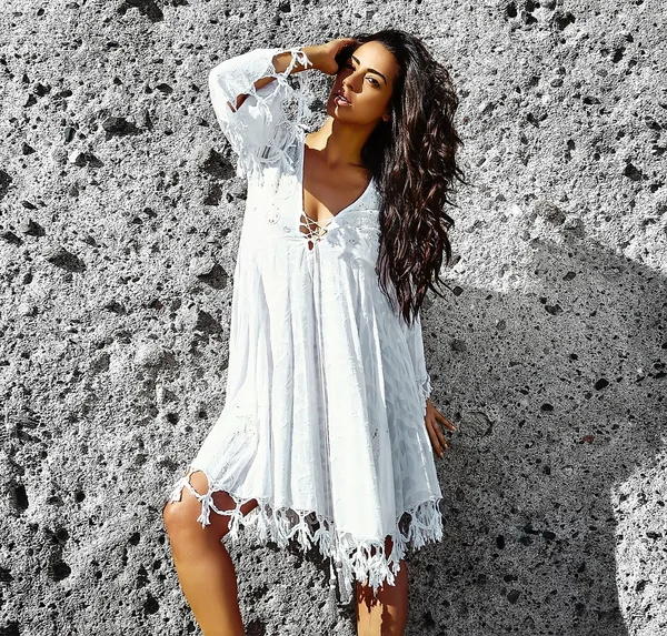 Foto de sensual sexy bonita jovem morena modelo hippie menina em vestido branco posando ao ar livre perto da parede cinza — Fotografia de Stock