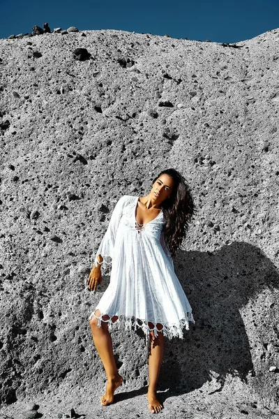 Foto de sensual sexy bonita jovem morena modelo hippie menina em vestido branco posando ao ar livre perto da parede cinza — Fotografia de Stock