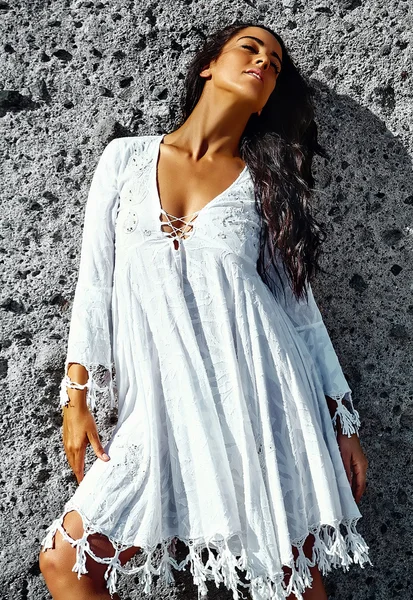 Foto de sensual sexy bonita jovem morena modelo hippie menina em vestido branco posando ao ar livre perto da parede cinza — Fotografia de Stock