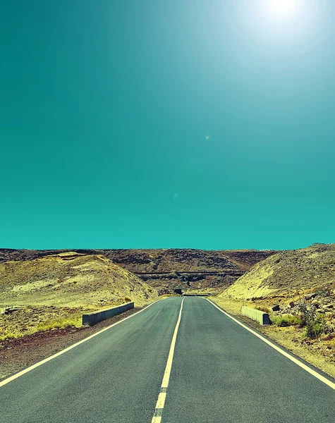 Camino de asfalto vacío con cielo azul y fondo desértico —  Fotos de Stock