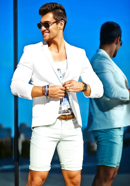 Aparência de alta moda.Young elegante confiante homem de modelo de empresário bonito feliz em roupas de terno branco posando e refletindo perto do espelho — Fotografia de Stock