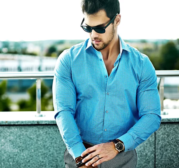 Retrato de moda de joven sexy guapo modelo hombre en ropa casual en gafas de sol en la calle — Foto de Stock