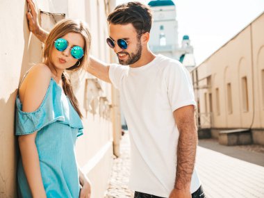 Gülümseyen güzel bir kadın ve yakışıklı erkek arkadaşının portresi. Yazlık kotlar içinde bir manken. Mutlu, neşeli bir aile. Kadın eğleniyor. Güneş gözlüklü bir çift sokakta poz veriyor.