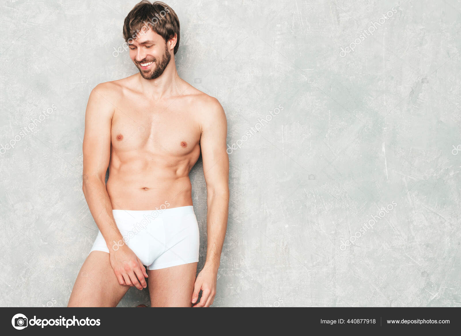 多姿多彩的英俊壮汉的画像健康的微笑运动健身模型穿着白色内裤靠灰墙摆姿势自信性感的男性赤身裸体lambersexual在工作室