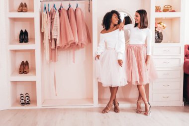 Son moda yaz elbiseleri içinde gülümseyen iki güzel uluslararası hippi kadın. Pembe gardıropta poz veren kaygısız seksi kadınlar. Pozitif modeller eğleniyor. Arkadaşlık kavramı 