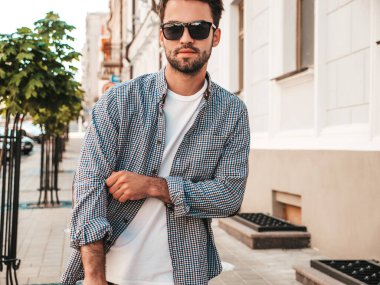 Yakışıklı, gülümseyen stil sahibi Lambersex modelinin portresi. Beyaz tişört giyen adam. Moda erkeği güneş gözlükleriyle sokakta poz veriyor. 