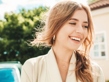 Güzel, gülümseyen esmer modelin yakın plan portresi. Günbatımında sokakta poz veren modaya uygun bir kadın. Komik ve pozitif kadın dışarıda eğleniyor.