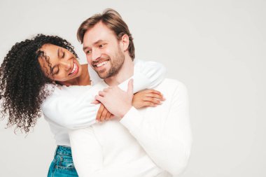 Gülümseyen güzel kadın ve yakışıklı erkek arkadaşı. Mutlu çok ırklı aile, gri arka planda hassas anlar yaşıyor. Çok ırklı modeller sarılıyor. Birbirimizi kucaklıyoruz. Aşk konsepti.