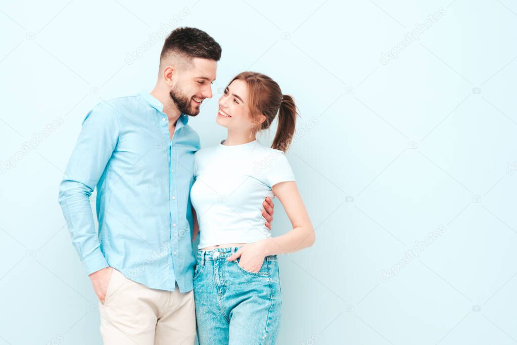 Smiling beautiful woman and her handsome boyfriend. Happy cheerful family having tender moments near light blue wall in studio.Pure cheerful models hugging.Embracing each other.Love concept