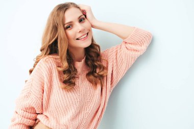 Son moda yaz hippi kıyafetleri içinde gülümseyen güzel bir kadının portresi. Stüdyoda açık mavi duvarın yanında poz veren kaygısız seksi kadın. Pozitif model içeride eğleniyor. Neşeli ve mutlu