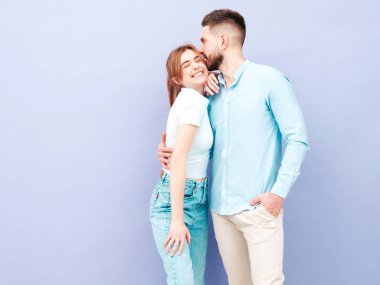 Gülümseyen güzel kadın ve yakışıklı erkek arkadaşı. Mutlu mutlu aile stüdyoda mor duvarın yanında hassas anlar yaşıyor. Saf, neşeli modeller sarılıyor. Birbirlerine sarılıyorlar. Aşk kavramı.