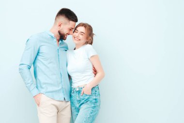 Gülümseyen güzel kadın ve yakışıklı erkek arkadaşı. Mutlu mutlu aile stüdyoda açık mavi duvarın yanında hassas anlar yaşıyor. Saf, neşeli modeller sarılıyor. Birbirlerine sarılıyorlar. Aşk kavramı.