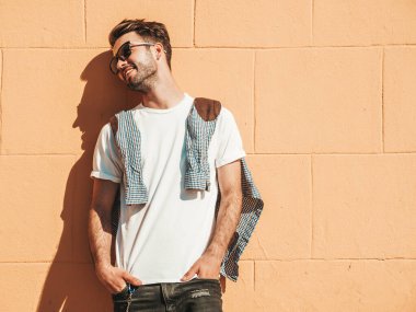 Yakışıklı, gülümseyen stil sahibi Lambersex modelinin portresi. Beyaz tişört giyen adam. Moda erkeği güneş gözlükleriyle sokakta poz veriyor. 