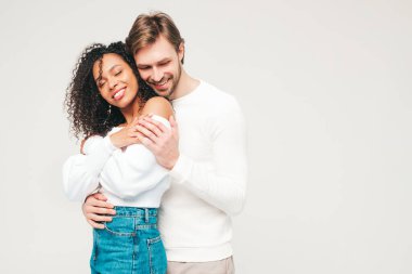 Gülümseyen güzel kadın ve yakışıklı erkek arkadaşı. Mutlu çok ırklı aile, gri arka planda hassas anlar yaşıyor. Çok ırklı modeller sarılıyor. Birbirimizi kucaklıyoruz. Aşk konsepti.