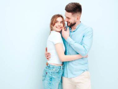 Gülümseyen güzel kadın ve yakışıklı erkek arkadaşı. Mutlu mutlu aile stüdyoda açık mavi duvarın yanında hassas anlar yaşıyor. Saf, neşeli modeller sarılıyor.