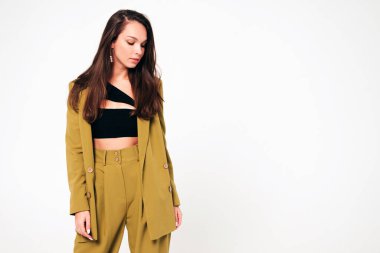 Moda kıyafetleri içinde gülümseyen genç ve güzel bir bayan. Stüdyoda gri arka planda poz veren kaygısız seksi kadın. Pozitif model içeride eğleniyor. Neşeli ve mutlu