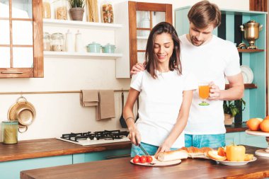 Gülümseyen güzel kadın ve onun yakışıklı erkek arkadaşı. Mutlu, sevgi dolu aile şefkatli anlar yaşıyor. Saf mankenler kahvaltı hazırlıyor.