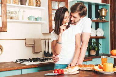 Gülümseyen güzel kadın ve onun yakışıklı erkek arkadaşı. Mutlu, sevgi dolu aile şefkatli anlar yaşıyor. Saf mankenler kahvaltı hazırlıyor.