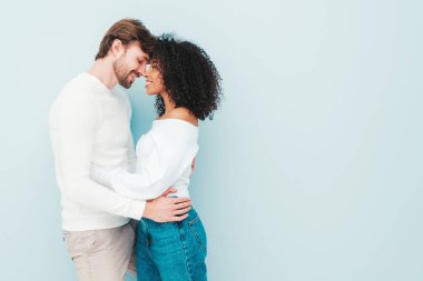 Gülümseyen güzel kadın ve yakışıklı erkek arkadaşı. Mutlu çok ırklı aile, gri arka planda hassas anlar yaşıyor. Çok ırklı modeller sarılıyor. Birbirimizi kucaklıyoruz. Aşk konsepti.