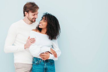 Gülümseyen güzel kadın ve yakışıklı erkek arkadaşı. Mutlu çok ırklı aile, gri arka planda hassas anlar yaşıyor. Çok ırklı modeller sarılıyor. Birbirimizi kucaklıyoruz. Aşk konsepti.