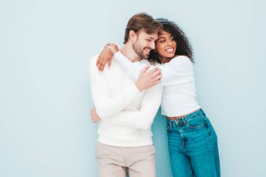 Gülümseyen güzel kadın ve yakışıklı erkek arkadaşı. Mutlu çok ırklı aile, gri arka planda hassas anlar yaşıyor. Çok ırklı modeller sarılıyor. Birbirimizi kucaklıyoruz. Aşk konsepti.