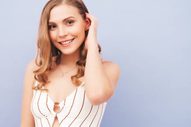 Son moda yaz hippi kıyafetleri içinde gülümseyen güzel bir kadının portresi. Stüdyoda mor duvarın yanında poz veren kaygısız seksi kadın. Pozitif model içeride eğleniyor. Neşeli ve mutlu