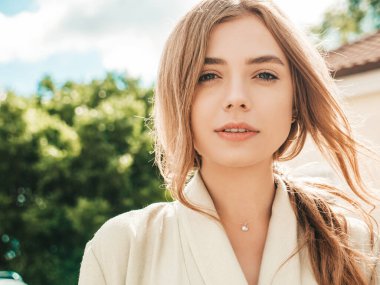 Güzel, gülümseyen sarışın modelin yakın plan portresi. Sokakta poz veren modaya uygun bir kadın. Komik ve pozitif bir kadın gün batımında dışarıda eğleniyor. Güzel ve neşeli.