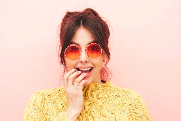 流行の夏の黄色のヒップスターセーターとジーンズの若い美しい笑顔の女性 スタジオでピンク色の壁の近くにポーズをとるセクシーな屈託のない女性 正のモデルは楽しみを持っています ショックと驚き — ストック写真