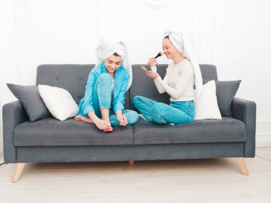 İki güzel, güzel, gülümseyen kadın lüks bir dairede ya da otel odasında poz veren kaygısız mankenler. Makyaj yapıyor, kafalarına havlu takıyor ve tırnaklarını ojeyle boyuyorlar.