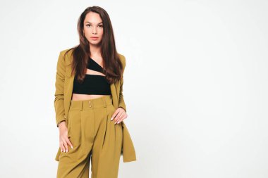 Moda kıyafetleri içinde gülümseyen genç ve güzel bir bayan. Stüdyoda gri arka planda poz veren kaygısız seksi kadın. Pozitif model içeride eğleniyor. Neşeli ve mutlu