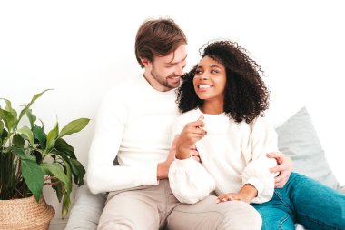 Gülümseyen güzel kadın ve yakışıklı erkek arkadaşı. Mutlu, çok ırklı aile şefkatli anlar yaşıyor. Yatakta yatan ve beyaz iç mekanlarda sarılan çok ırklı modeller. Birbirinize sarılın.