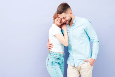 Gülümseyen güzel kadın ve yakışıklı erkek arkadaşı. Mutlu mutlu aile stüdyoda mor duvarın yanında hassas anlar yaşıyor. Saf, neşeli modeller sarılıyor. Birbirlerine sarılıyorlar. Kafa kafaya öpüşüyorlar.