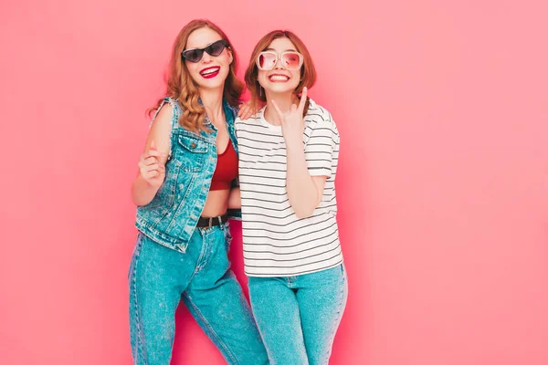 两个年轻美丽的嬉皮士女穿着时髦的夏季嬉皮士服装 无忧无虑的性感女人在工作室粉红的墙边摆姿势 时尚和积极的模型有乐趣 快乐而快乐 — 图库照片