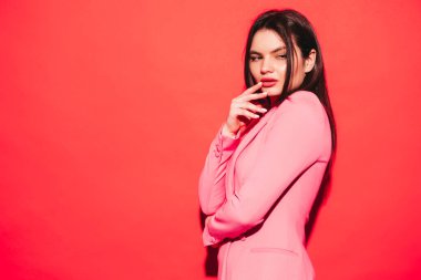 Stüdyoda kırmızı duvarın yanında poz veren güzel, esmer, güzel, güzel, güzel bir kadının moda portresi.
