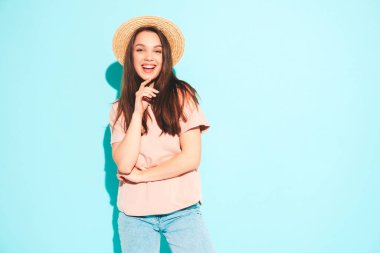 Son moda yaz hippi kıyafetleri içinde gülümseyen güzel bir kadının portresi. Stüdyoda mavi duvarın yanında poz veren kaygısız seksi kadın. Pozitif model şapkayla eğleniyor. Neşeli ve mutlu