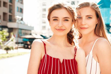 Son moda giyinmiş iki güzel, gülümseyen hippi kadın. Sokakta poz veren kaygısız kadınlar. Pozitif modeller eğleniyor, sarılıyor ve deliriyor. Güzellik konsepti.