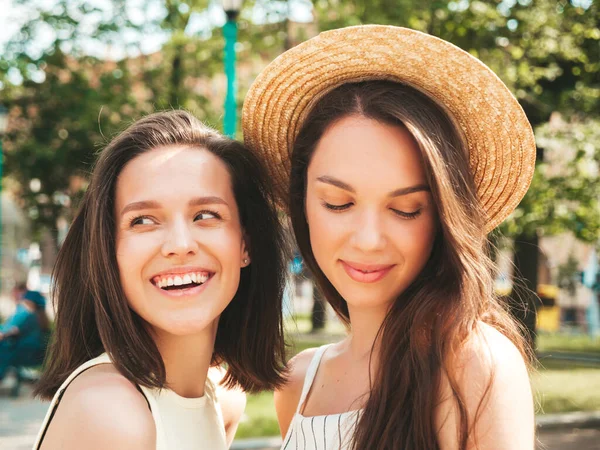 两个年轻美丽的嬉皮士女人穿着时髦的夏装 穿着无忧无虑的性感女人头戴帽子站在街上 正宗纯正的模特在日落时开心地拥抱 — 图库照片