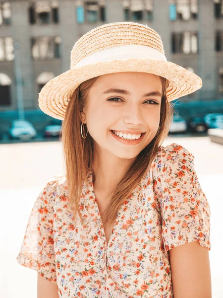 Young beautiful smiling hipster woman in trendy summer dress. Sexy carefree woman posing on the street background in hat at sunset. Positive model laughing outdoors. Cheerful and happy