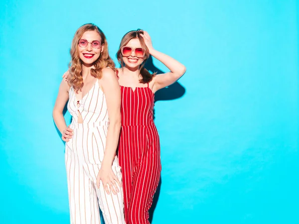 两个年轻美丽的嬉皮士女穿着时髦的夏季工作服 无忧无虑的性感女性在工作室的蓝色墙壁附近摆姿势 时尚和积极的模型有乐趣 快乐而快乐 — 图库照片