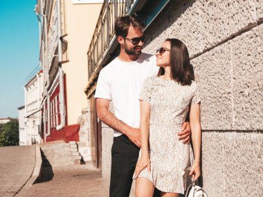 Gülümseyen güzel kadın ve yakışıklı erkek arkadaşı. Gündelik yaz kıyafetleri giymiş bir kadın. Mutlu, neşeli bir aile. Kadın eğleniyor. Güneş gözlükleriyle sokakta poz veren çift. Birbirlerine sarılıyorlar.