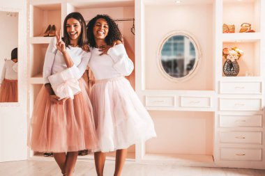 İki güzel, gülümseyen uluslararası hippi kadın, kaygısız kadınlar Noel ağacının yanında oturuyorlar. Pozitif mankenler sarılıyor. Noel, Noel, konsept