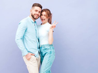 Gülümseyen güzel kadın ve yakışıklı erkek arkadaşı. Mutlu mutlu aile stüdyoda mor duvarın yanında hassas anlar yaşıyor. Saf, neşeli modeller sarılıyor.