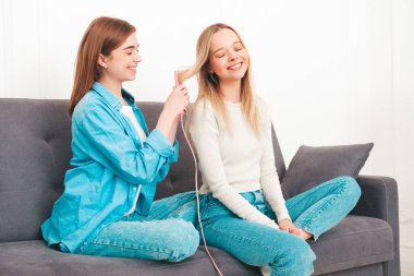 İki güzel, güzel, gülümseyen kadın lüks bir dairede ya da otel odasında poz veren kaygısız mankenler. Makyaj yapıyorlar ve kafalarına havlularla güzellik tedavisi yapıyorlar. Kıvrımlı bigudiler