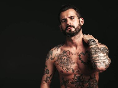 Yakışıklı, kendine güvenen, stil sahibi hipster Lambersex modelinin portresi. Seksi, modern adam. Dövmeli çıplak gövde. Stüdyoda siyah arka planda poz veren moda erkek.