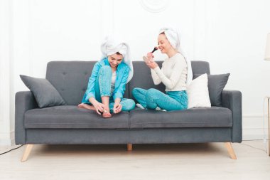 İki güzel, güzel, gülümseyen kadın lüks bir dairede ya da otel odasında poz veren kaygısız mankenler. Makyaj yapıyor, kafalarına havlu takıyor ve tırnaklarını ojeyle boyuyorlar.