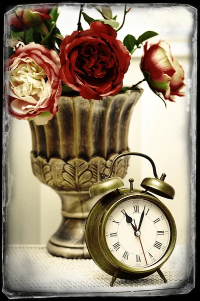 Classic clock  watch in bright colorful retro interior behind red flowers — Stock Photo, Image