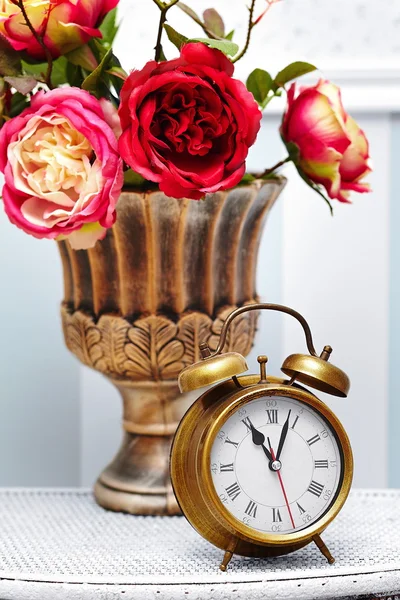 Classic clock  watch in bright colorful retro interior behind red flowers — Stock Photo, Image