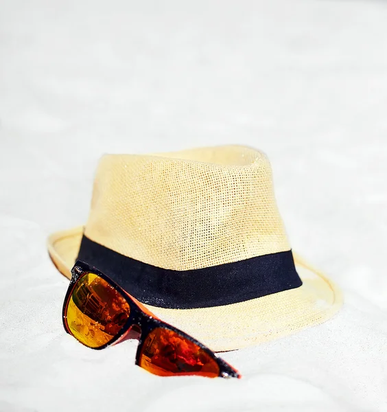 Sombrero y gafas de sol de colores en la playa de verano arena blanca cerca del océano azul —  Fotos de Stock