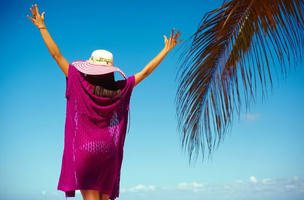 Vysoce módní vzhled. zadní strana Glamour sexy model dívka v barevné tkaniny a klobouku proti slunci seběhla za modré pláže oceán vody — Stock fotografie