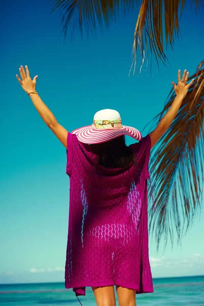 High fashion look. back of glamor sexy model girl  in colorful cloth and sunhat behind blue beach ocean water — Stock Photo, Image